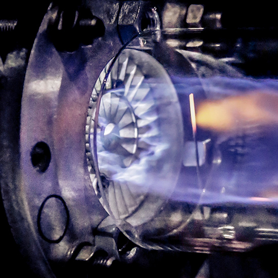 Round machinery creating a large blue flame
